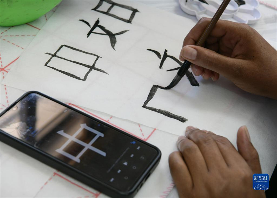 4月18日，肯尼亞學(xué)生在內(nèi)羅畢大學(xué)孔子學(xué)院舉辦的活動(dòng)上寫毛筆字。肯尼亞內(nèi)羅畢大學(xué)孔子學(xué)院18日舉辦“中文，增進(jìn)文明對(duì)話”主題活動(dòng)，慶祝即將到來的第14個(gè)聯(lián)合國(guó)中文日?？夏醽唽W(xué)生參與互動(dòng)，進(jìn)行書法、剪紙、唱中文歌等活動(dòng)。新華社記者 韓旭 攝
