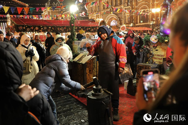 游客在新年集市上體驗(yàn)制作紀(jì)念幣。人民網(wǎng)記者 隋鑫攝