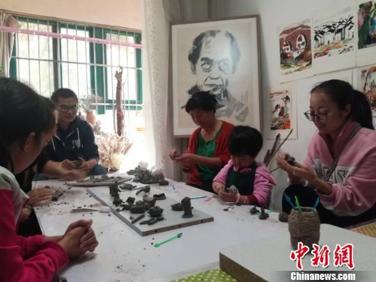 劉雪玲和孩子家長(zhǎng)一起創(chuàng)作泥塑作品?！＄娦?攝