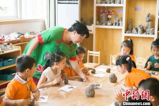 圖為劉雪玲正在給幼教中心的孩子上泥塑課。　鐘欣 攝