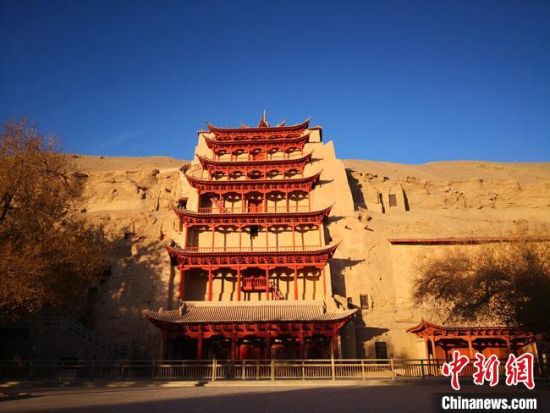 圖為11月7日，沐浴在晨光中的敦煌莫高窟標志性建筑“九層樓”。　馮志軍 攝