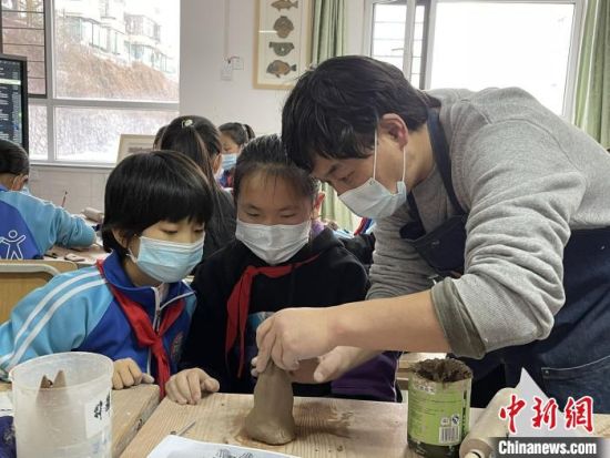 圖為西寧市勞動路小學(xué)教師賈煜與學(xué)生一起制作陶藝。　周瑞辰子 攝