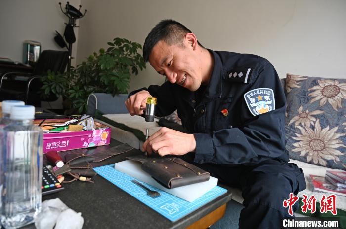 圖為工作之余，王微在做手工?！≮w朗 攝