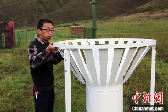 圖為班瑪縣氣象局工作人員在維護藏雪茶基地氣候站。青海省氣象局供圖