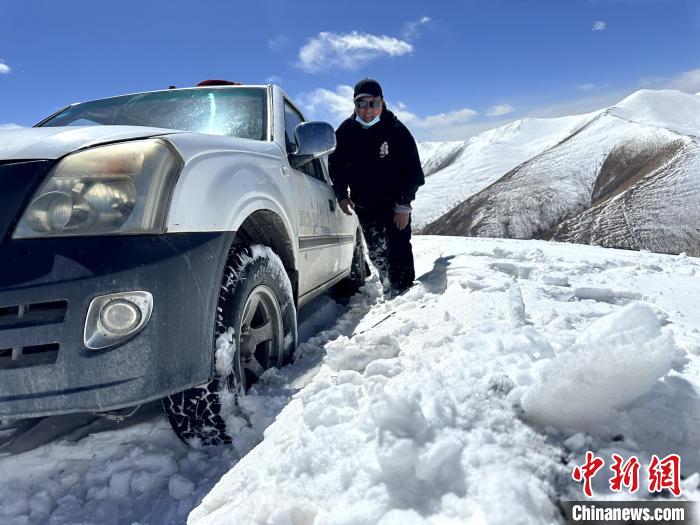 圖為生態(tài)管護人員準備在雪地推車?！《“瓦_杰 攝