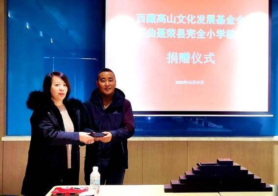 圖為西藏高山文化發(fā)展基金會(huì)理事長(zhǎng)溫麗向聶榮縣完全小學(xué)負(fù)責(zé)人捐助儀器?！∮谫e 攝