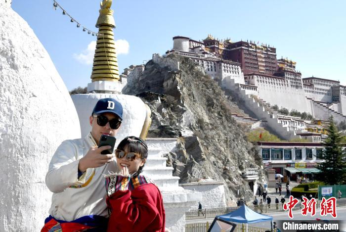 4月17日，游客身著藏式元素服裝在拉薩布達拉宮觀景臺拍照留念?！±盍?攝